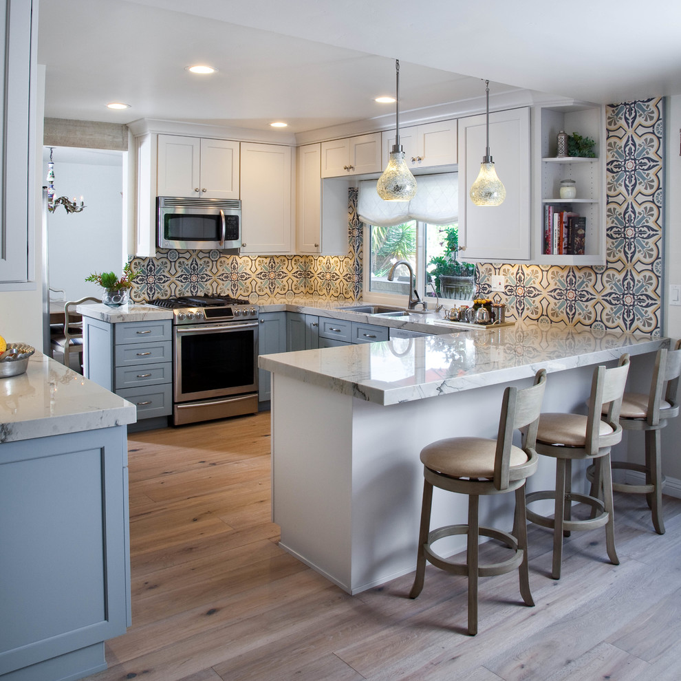 Mid-sized transitional u-shaped light wood floor and multicolored floor enclosed kitchen photo in San Diego with an undermount sink, shaker cabinets, blue cabinets, quartzite countertops, multicolored backsplash, cement tile backsplash and stainless steel appliances