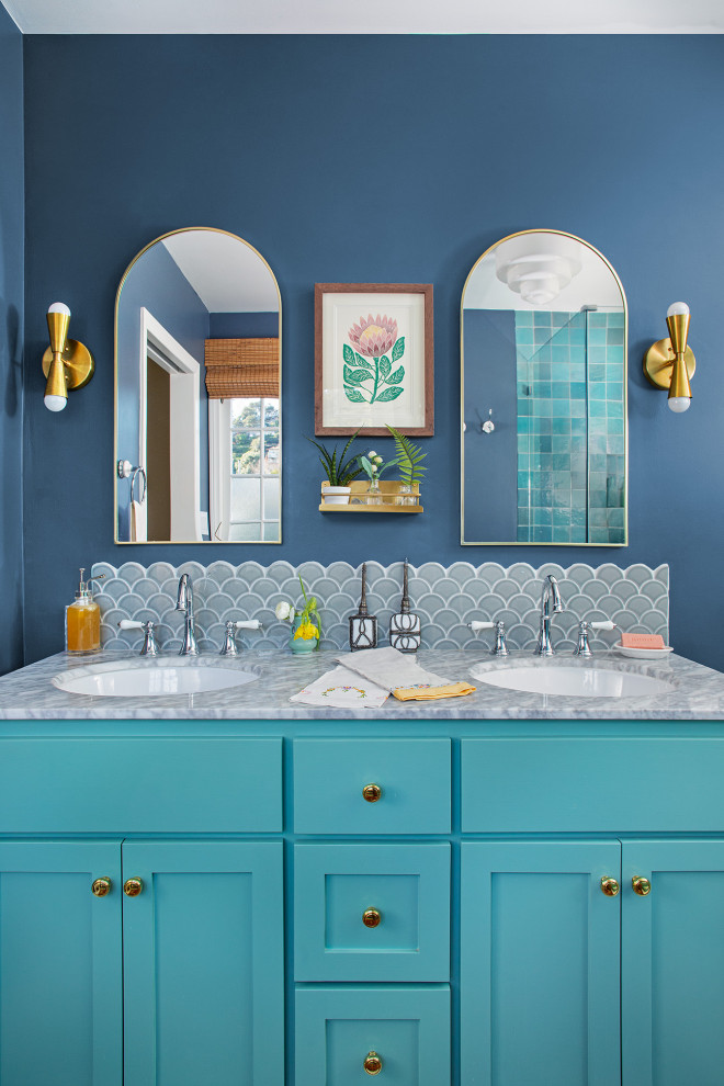 Idées déco pour une salle de bain éclectique avec un placard à porte shaker, des portes de placard turquoises, un mur bleu, un lavabo encastré, un plan de toilette gris et meuble double vasque.