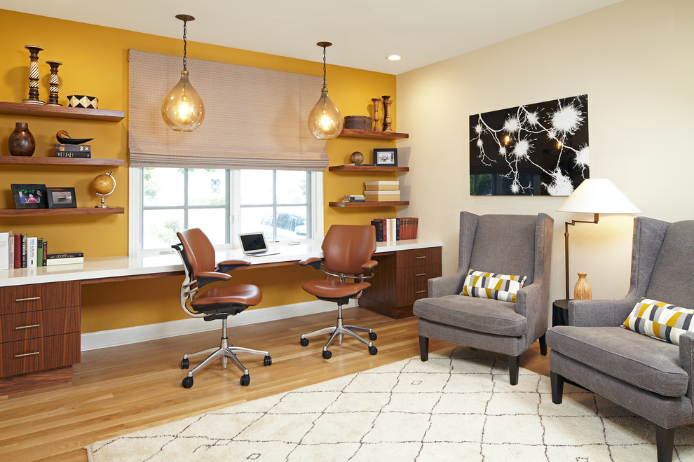 Large transitional built-in desk light wood floor study room photo in Los Angeles with yellow walls and no fireplace