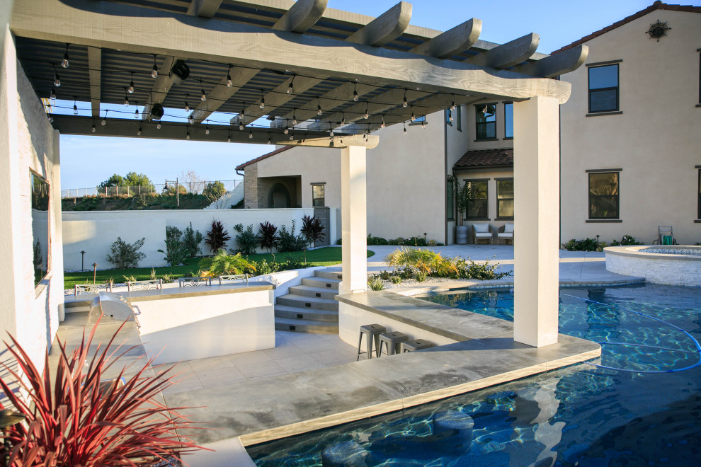 Immagine di una piscina naturale classica personalizzata di medie dimensioni e dietro casa con una dépendance a bordo piscina e piastrelle