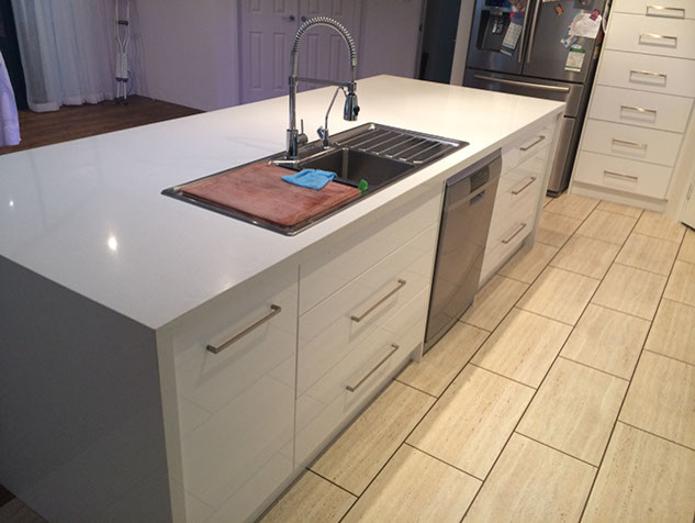 Small modern single-wall eat-in kitchen in Perth with an undermount sink, flat-panel cabinets, white cabinets, quartz benchtops, white splashback, glass sheet splashback, stainless steel appliances, light hardwood floors and with island.
