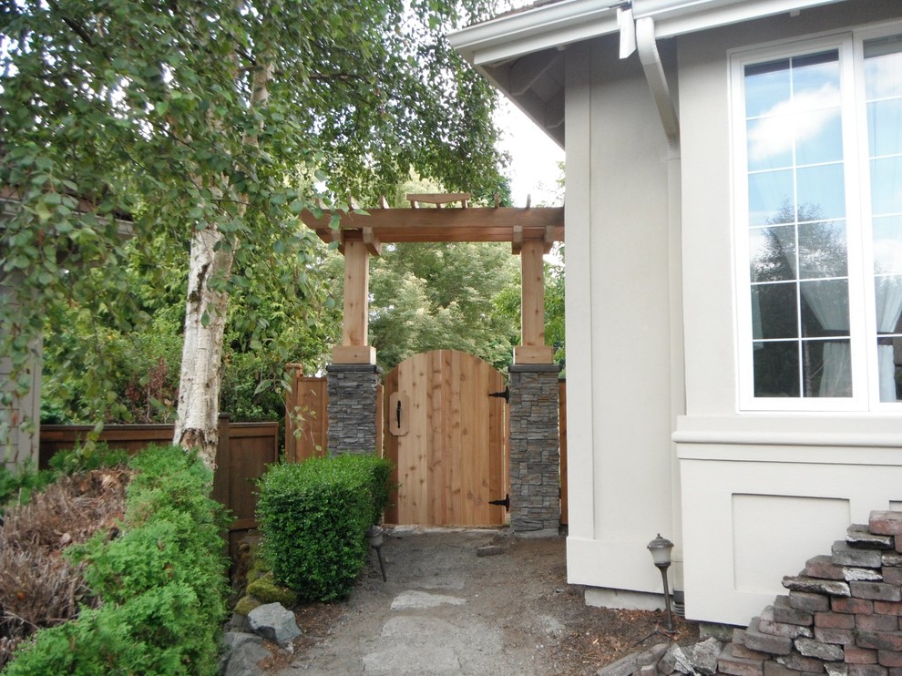 Inspiration for a mid-sized transitional side yard partial sun garden in Seattle with natural stone pavers.