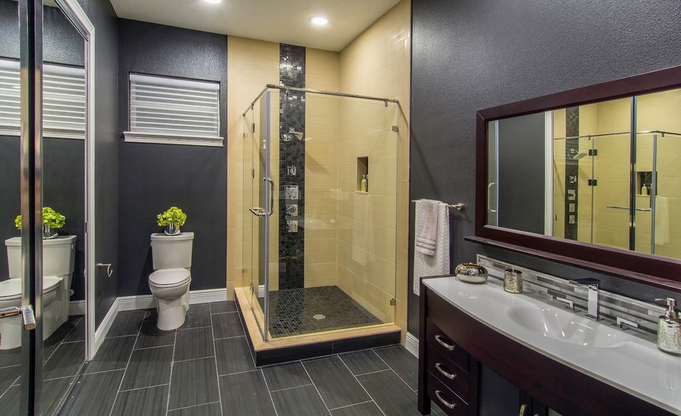This is an example of a large transitional 3/4 bathroom in Tampa with dark wood cabinets, a corner shower, porcelain tile, porcelain floors, solid surface benchtops, flat-panel cabinets, a two-piece toilet, black tile, yellow tile, black walls and an integrated sink.