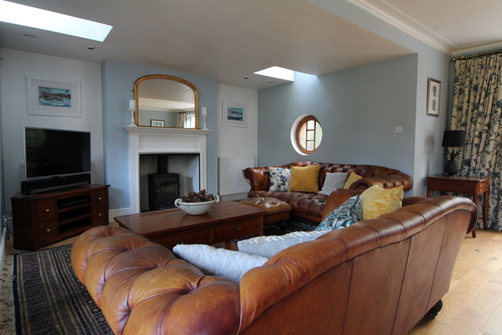 Design ideas for a large traditional living room in Cambridgeshire with blue walls and light hardwood floors.