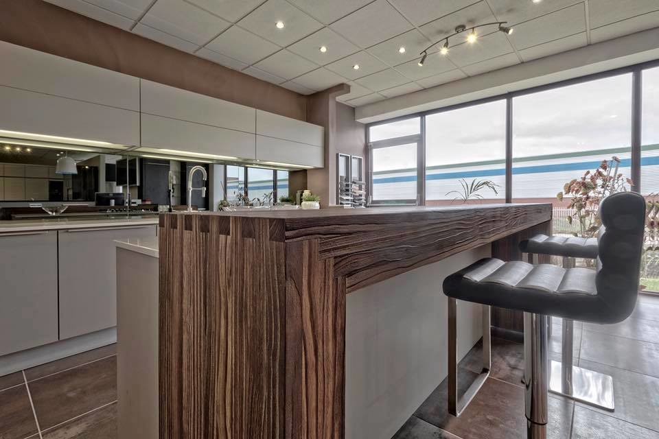 Mid-sized contemporary galley eat-in kitchen in Houston with flat-panel cabinets, beige cabinets, laminate benchtops, mirror splashback, stainless steel appliances, ceramic floors and with island.