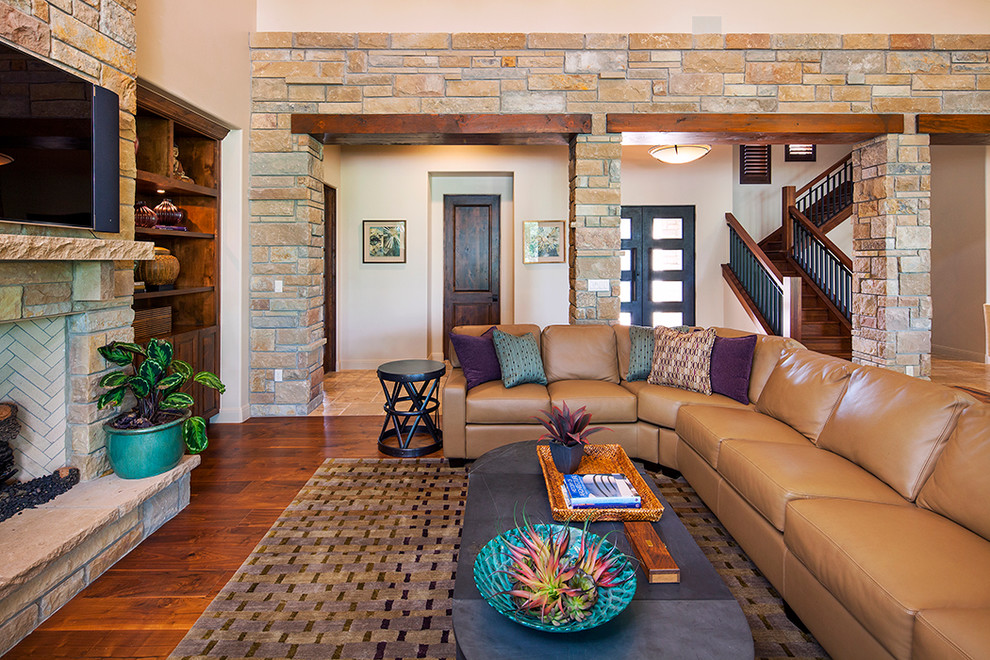 Design ideas for a large transitional open concept living room in Austin with beige walls, dark hardwood floors, a standard fireplace, a brick fireplace surround and a wall-mounted tv.