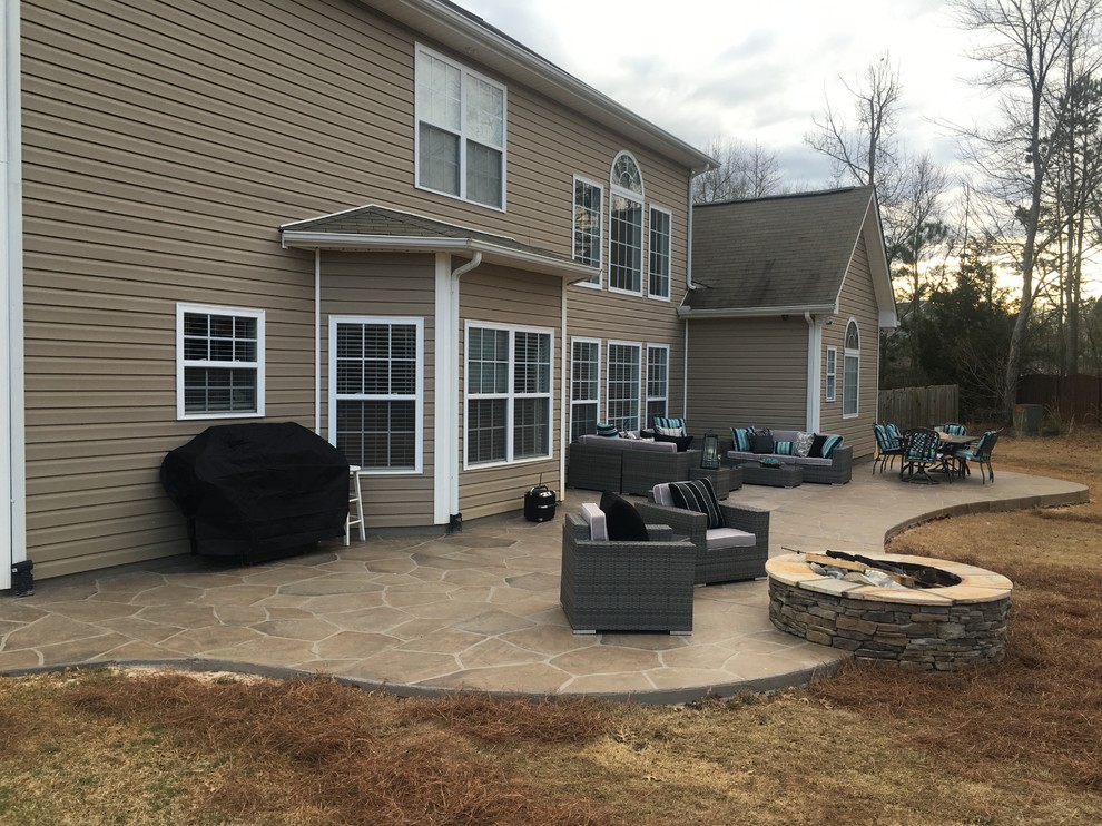 Patio - mid-sized transitional backyard stamped concrete patio idea in Other with no cover