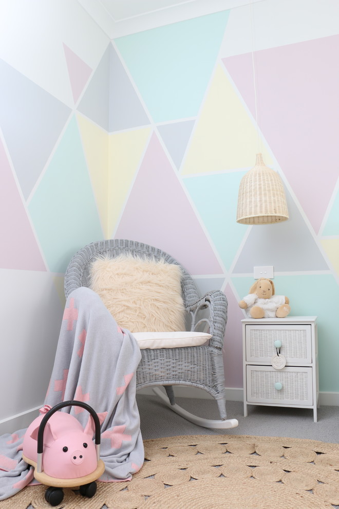 Mid-sized scandinavian nursery in Sydney with multi-coloured walls and carpet for girls.