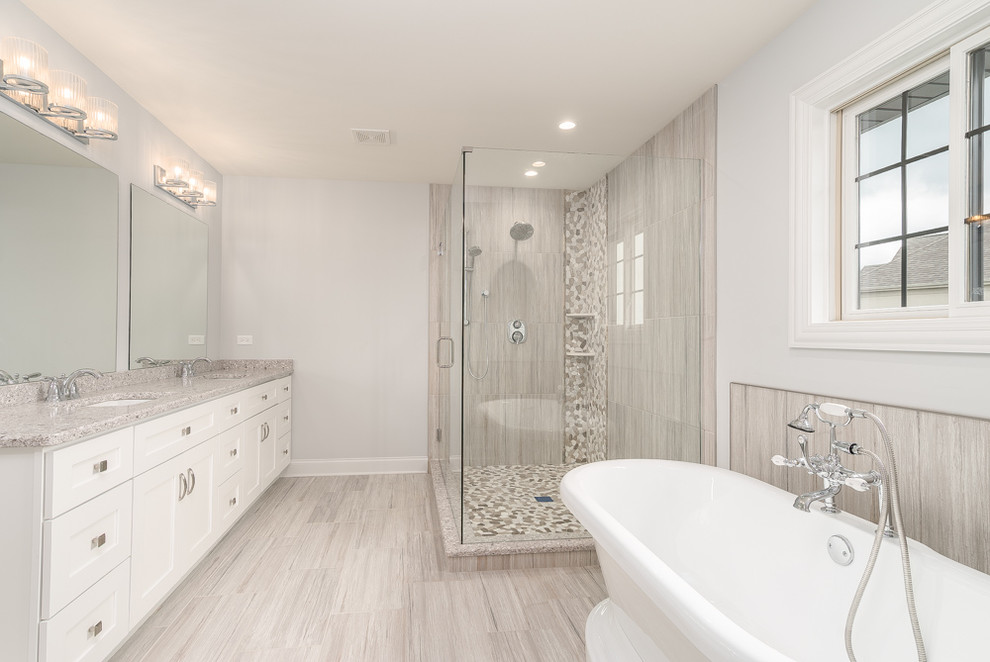 Inspiration for a mid-sized transitional master bathroom in Chicago with white cabinets, a freestanding tub, a corner shower, beige tile, brown tile, gray tile, white tile, porcelain tile, grey walls, porcelain floors, an undermount sink, beige floor, a hinged shower door, recessed-panel cabinets, a two-piece toilet, terrazzo benchtops and grey benchtops.