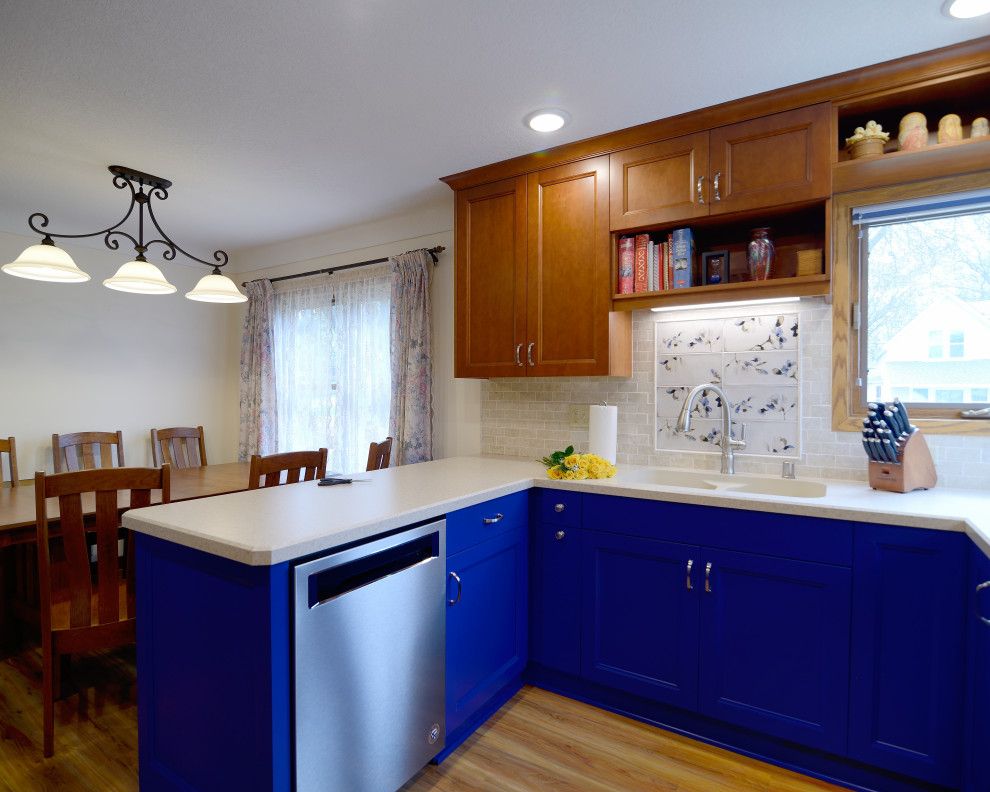 Small eclectic u-shaped eat-in kitchen in Minneapolis with an undermount sink, shaker cabinets, blue cabinets, laminate benchtops, beige splashback, travertine splashback, stainless steel appliances, laminate floors, brown floor and beige benchtop.