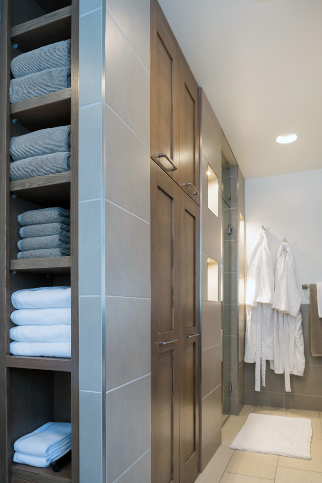 Photo of a mid-sized modern master bathroom in Other with shaker cabinets, brown cabinets, a freestanding tub, a curbless shower, a one-piece toilet, gray tile, cement tile, grey walls, porcelain floors, an undermount sink and concrete benchtops.