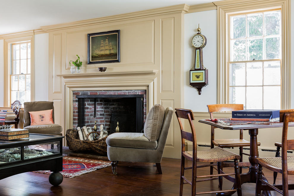 This is an example of a traditional enclosed living room in Boston with yellow walls, a standard fireplace, a brick fireplace surround and no tv.