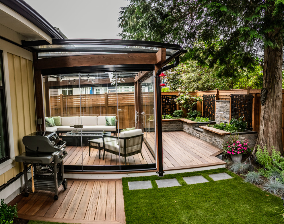 This is an example of a mid-sized contemporary backyard garden in Vancouver with with privacy feature.