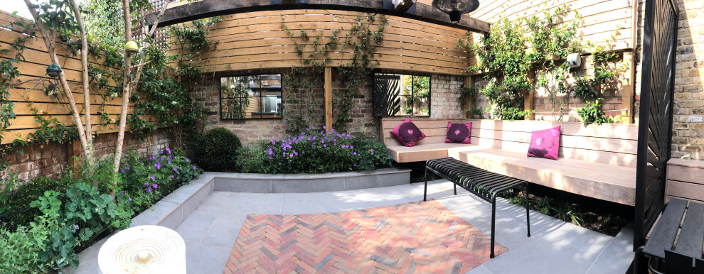 Idee per un piccolo patio o portico industriale dietro casa con pavimentazioni in mattoni e una pergola