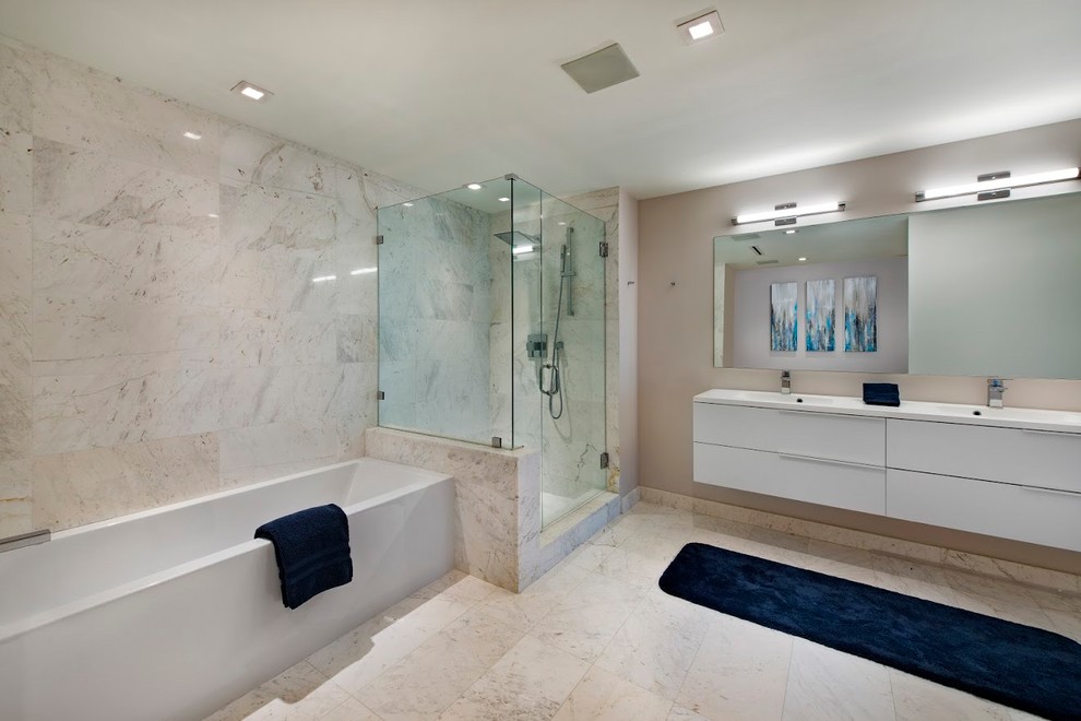 This is an example of a mid-sized contemporary master bathroom in Miami with flat-panel cabinets, white cabinets, a corner tub, a corner shower, a two-piece toilet, white tile, white walls, an integrated sink and a hinged shower door.