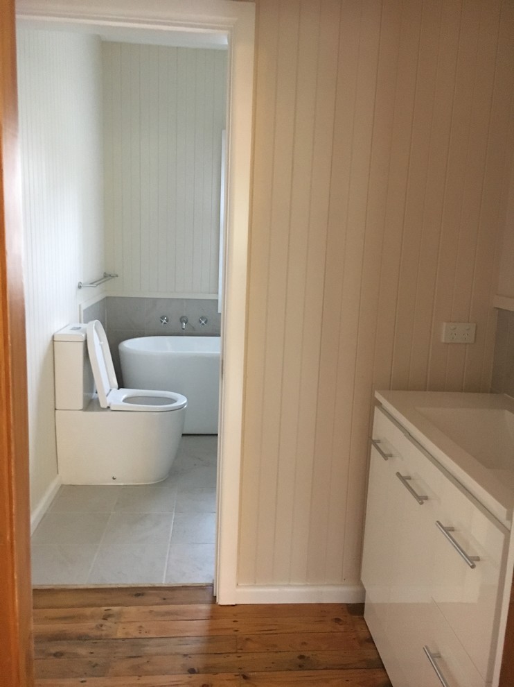 Small contemporary 3/4 bathroom in Other with white cabinets, a freestanding tub, a corner shower, beige tile, ceramic tile, ceramic floors, an integrated sink, beige floor, a hinged shower door and white benchtops.