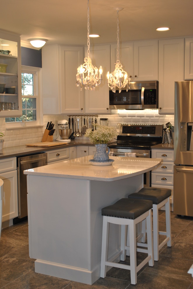 Inspiration for a transitional l-shaped brown floor eat-in kitchen remodel in St Louis with an undermount sink, shaker cabinets, white cabinets, quartz countertops, white backsplash, subway tile backsplash, stainless steel appliances and an island