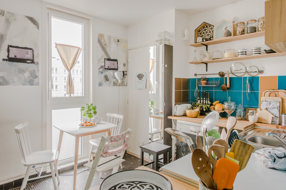 This is an example of an eclectic l-shaped eat-in kitchen in Montpellier with a double-bowl sink, open cabinets, wood benchtops, blue splashback, no island, multi-coloured floor and beige benchtop.