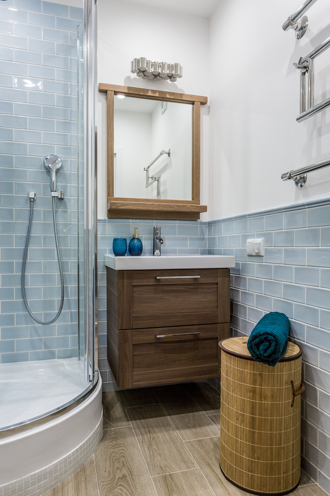 Пример оригинального дизайна: ванная комната с бежевыми фасадами, угловым душем, унитазом-моноблоком, синей плиткой, керамической плиткой, синими стенами, полом из керамической плитки и консольной раковиной