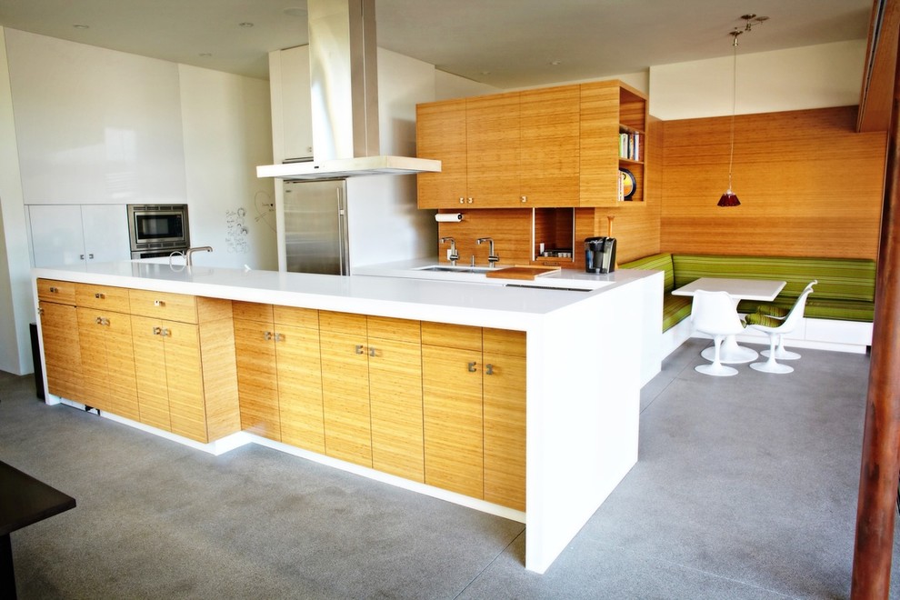 Photo of a large contemporary l-shaped open plan kitchen in Seattle with flat-panel cabinets, white cabinets, with island, an undermount sink, quartz benchtops, brown splashback, timber splashback, stainless steel appliances, concrete floors, grey floor and white benchtop.
