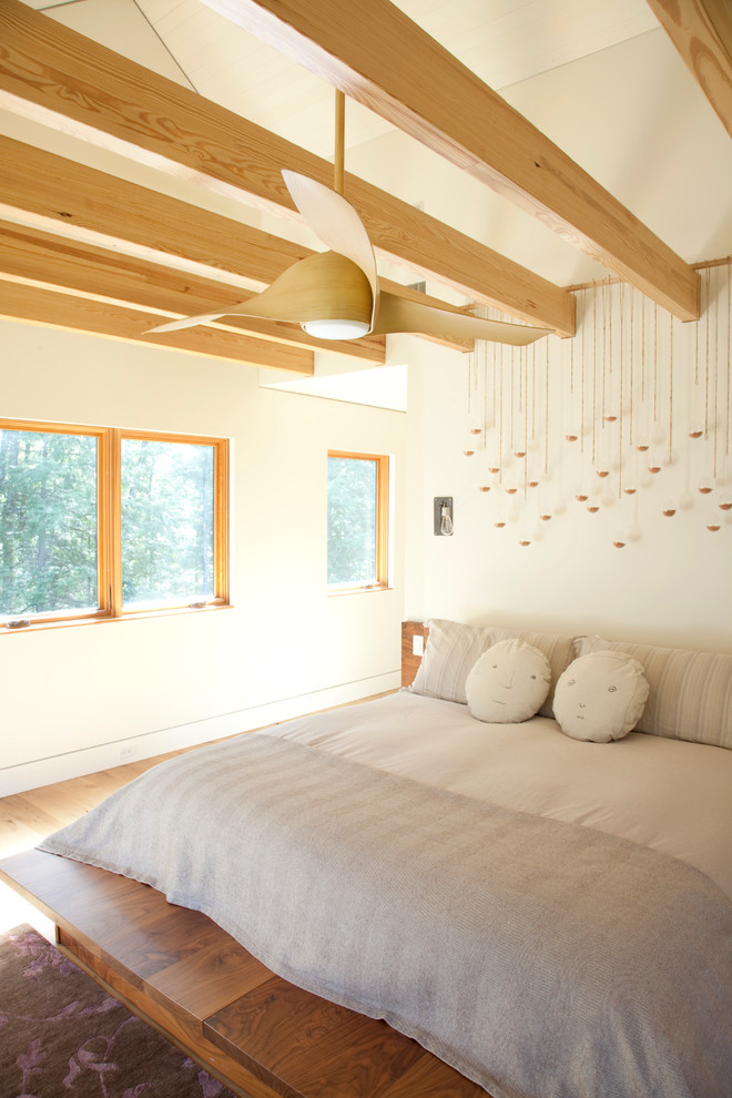 Photo of a contemporary master bedroom in New York with white walls and light hardwood floors.