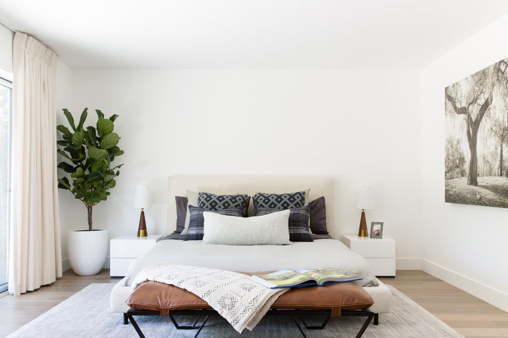 Inspiration for a contemporary light wood floor and beige floor bedroom remodel with white walls