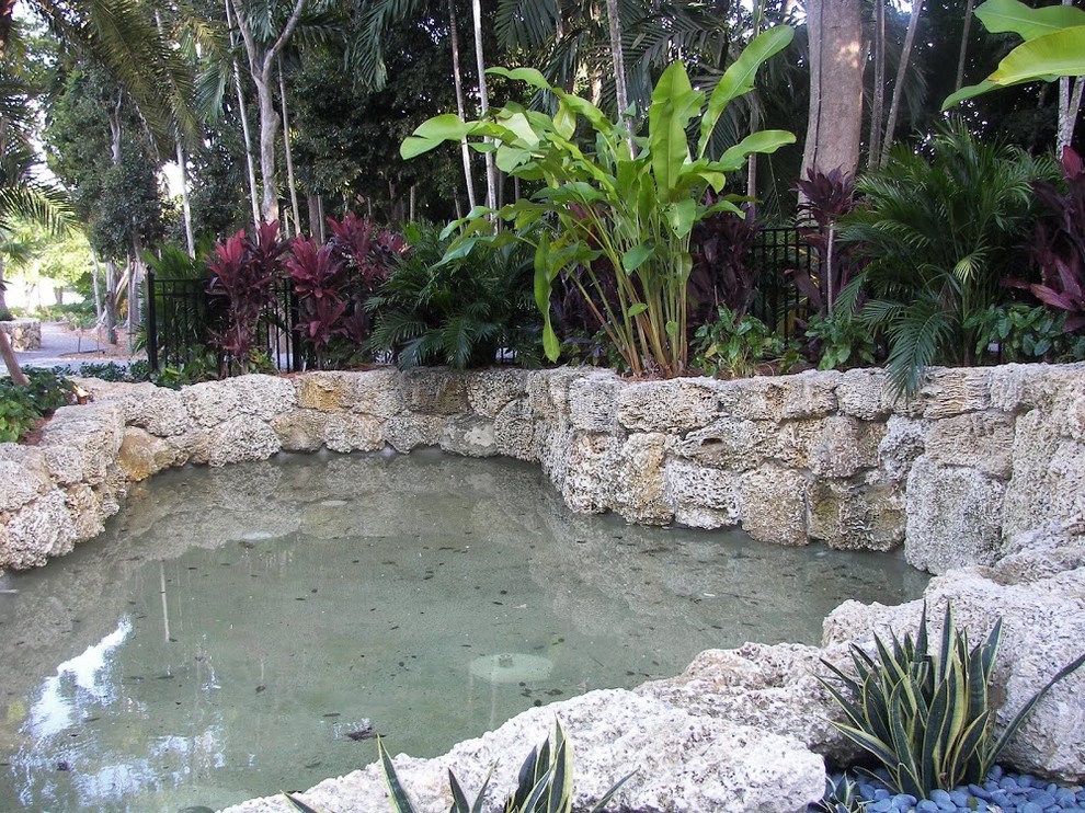 Pool fountain - transitional backyard stone and custom-shaped aboveground pool fountain idea in Miami