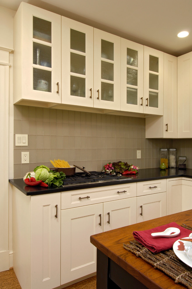 Mid-sized transitional u-shaped light wood floor and beige floor eat-in kitchen photo in DC Metro with an undermount sink, shaker cabinets, white cabinets, granite countertops, green backsplash, glass tile backsplash, white appliances and an island