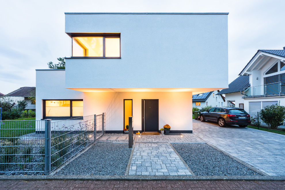 Inspiration for a mid-sized contemporary two-storey stucco white exterior in Frankfurt with a flat roof.