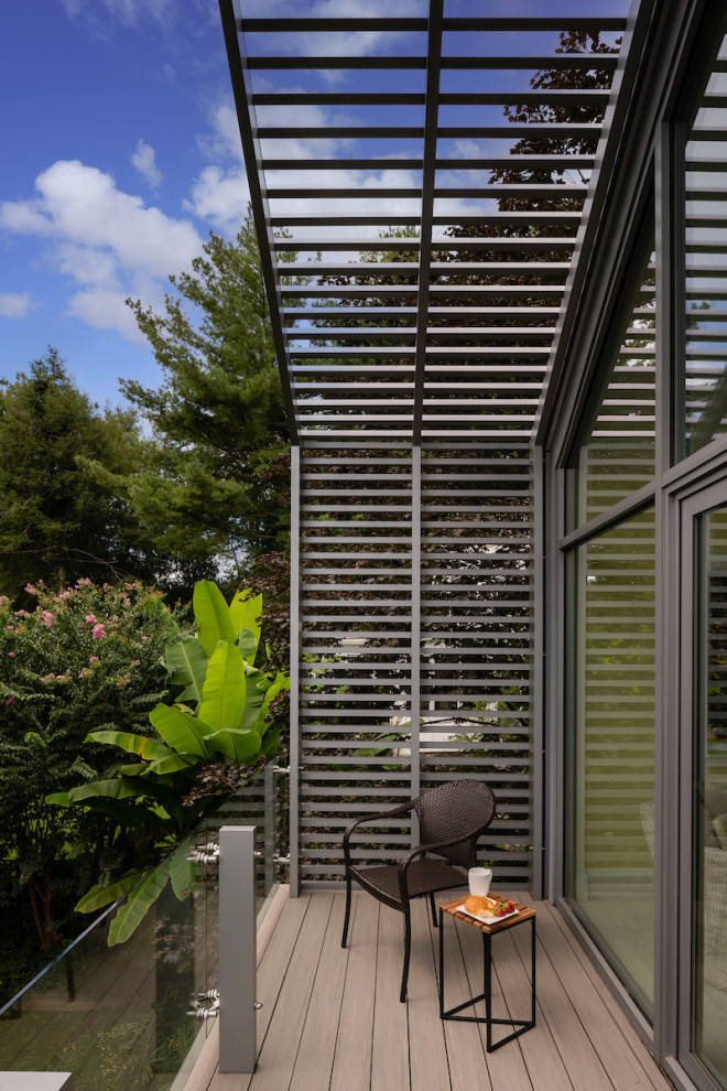 Inspiration pour un balcon minimaliste de taille moyenne avec des solutions pour vis-à-vis, une extension de toiture et un garde-corps en métal.