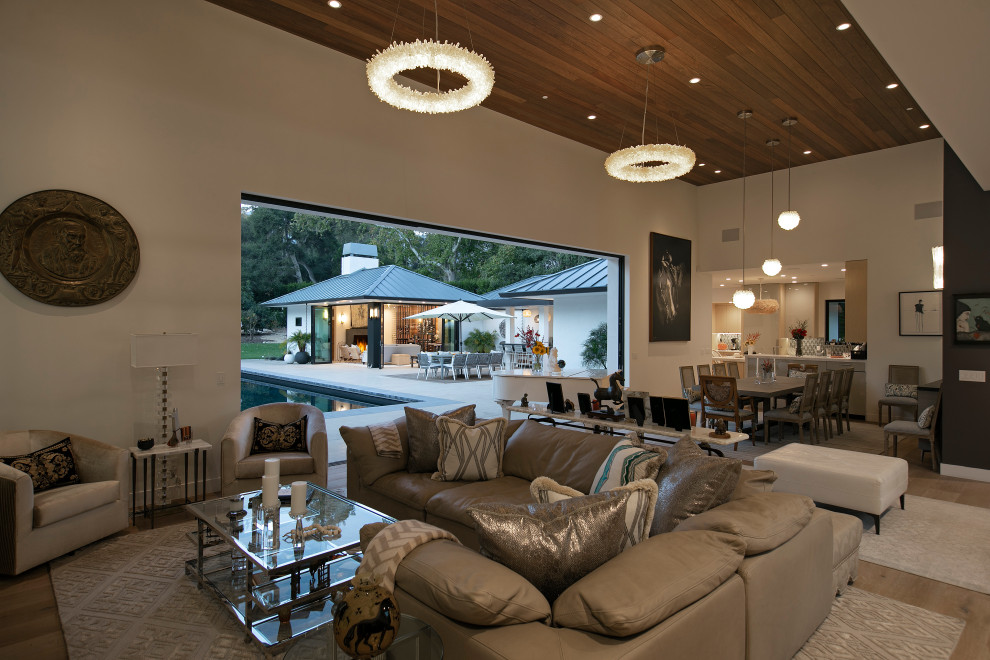 Photo of an expansive modern open plan living room in Santa Barbara with a standard fireplace, a stone fireplace surround, a concealed tv and a wood ceiling.