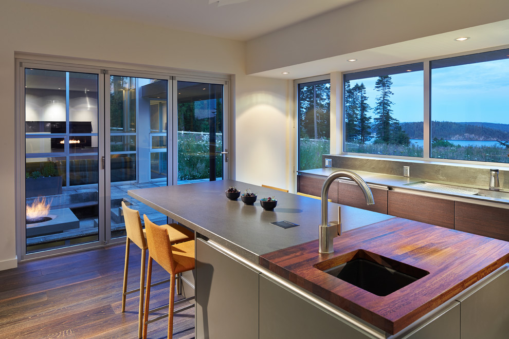 Inspiration for a contemporary kitchen in Seattle with an undermount sink, flat-panel cabinets, dark wood cabinets, dark hardwood floors and with island.