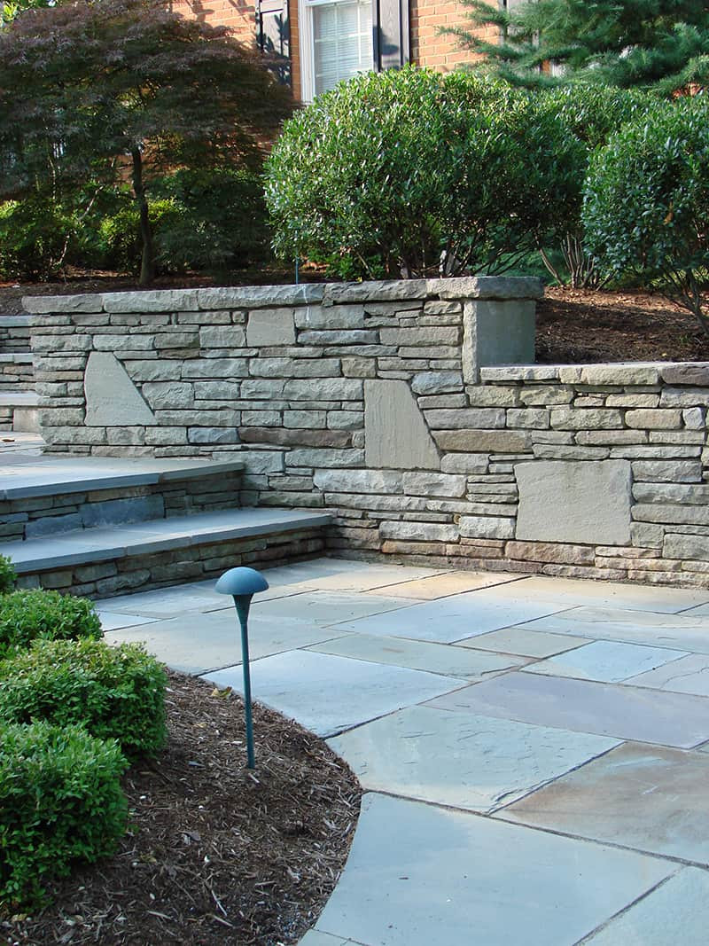 Flagstone Retaining wall. We deigned this wall as we wanted the wall to be an interesting conversation. The flagstone pavers match some of the colors found in the stone. Peter Atkins and Associates.