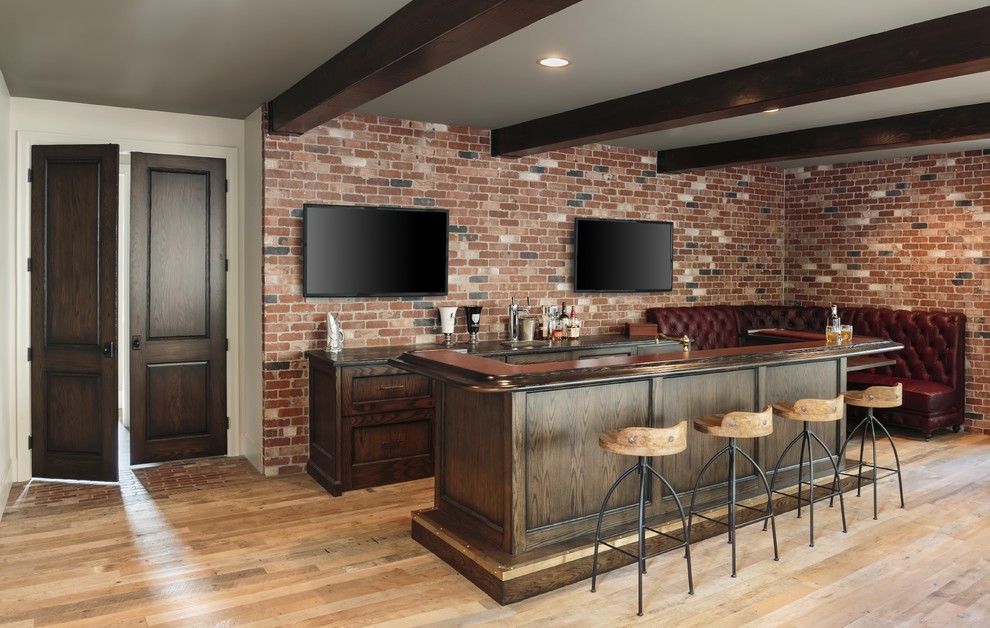Inspiration for a large industrial l-shaped seated home bar in Portland with an undermount sink, dark wood cabinets, wood benchtops, medium hardwood floors, red splashback, brick splashback, brown floor and brown benchtop.