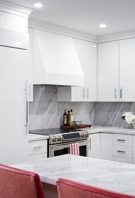 Inspiration for a small traditional u-shaped eat-in kitchen in Toronto with an undermount sink, flat-panel cabinets, white cabinets, marble benchtops, white splashback, marble splashback, panelled appliances, dark hardwood floors, brown floor and a peninsula.