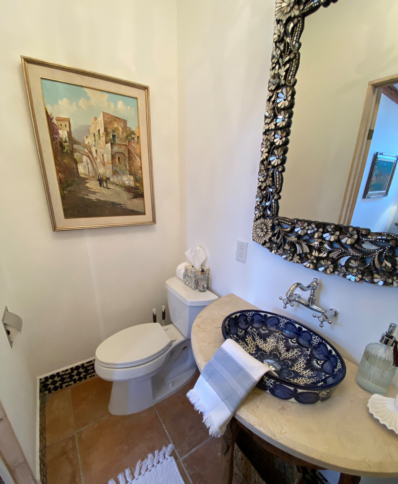 Bathroom - small mediterranean 3/4 white tile and cement tile terra-cotta tile, orange floor, single-sink and exposed beam bathroom idea in San Diego with distressed cabinets, a two-piece toilet, white walls, a vessel sink, marble countertops, beige countertops and a freestanding vanity