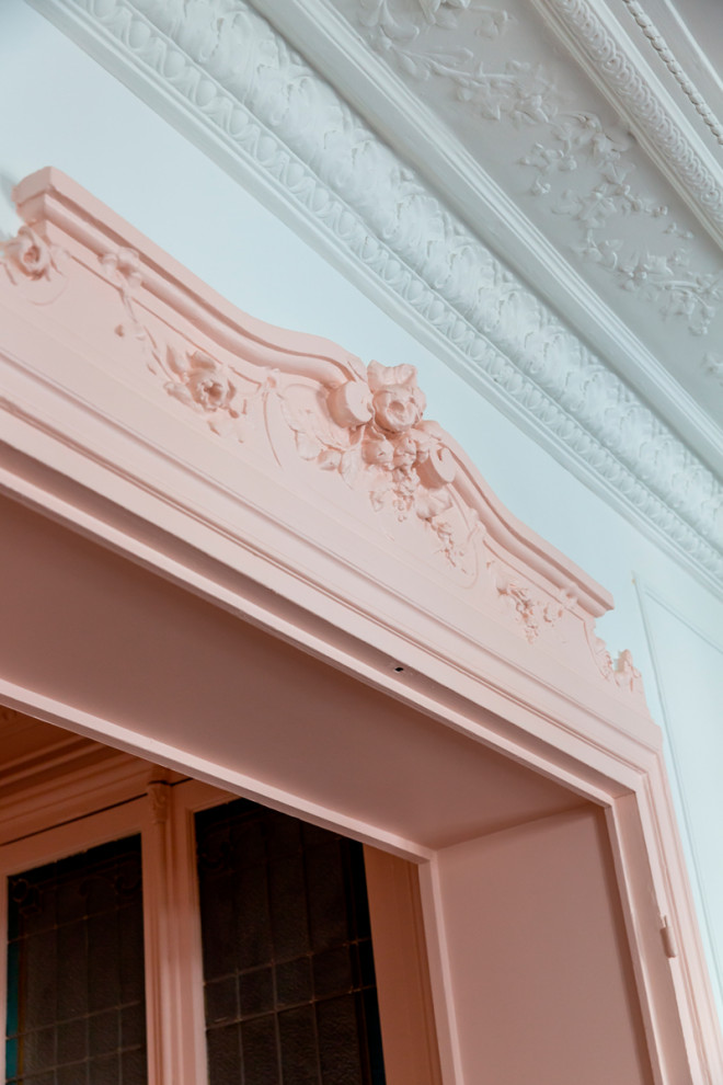 Ejemplo de hall abovedado actual de tamaño medio con paredes rosas, suelo de madera en tonos medios, puerta simple y suelo marrón