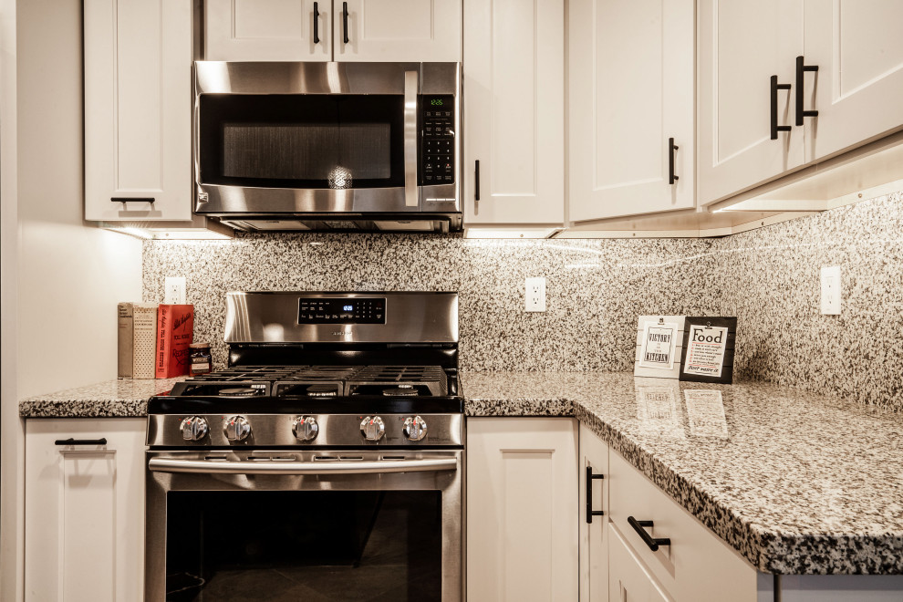 Inspiration for a large transitional medium tone wood floor and red floor open concept kitchen remodel in Phoenix with an undermount sink, shaker cabinets, white cabinets, granite countertops, multicolored backsplash, granite backsplash, stainless steel appliances, an island and multicolored countertops