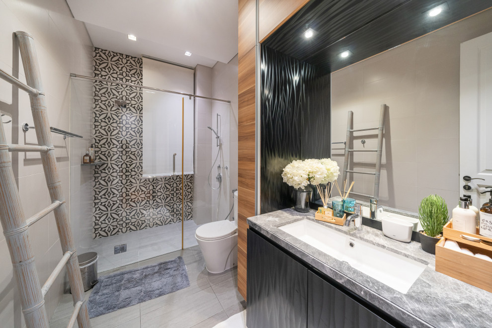Inspiration for a contemporary bathroom in Singapore with flat-panel cabinets, black cabinets, an alcove shower, black and white tile, an undermount sink, grey floor, a hinged shower door, grey benchtops, a single vanity and a built-in vanity.