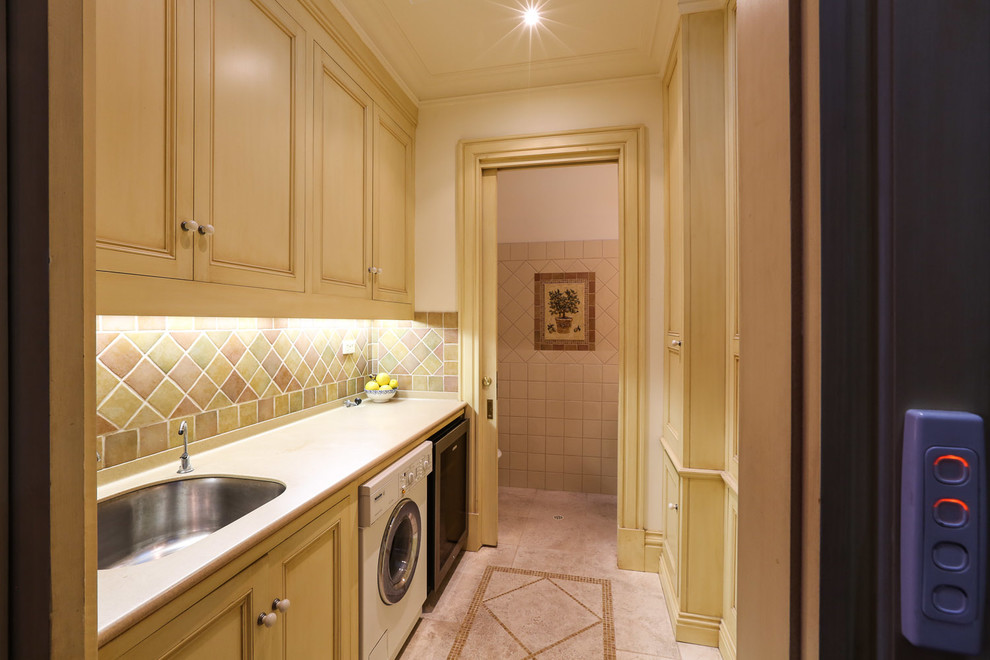 This is an example of a small traditional galley utility room in Adelaide with beaded inset cabinets, solid surface benchtops and light wood cabinets.