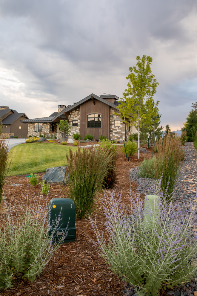 Photo of an expansive arts and crafts front yard full sun driveway in Denver with with rock feature and mulch.