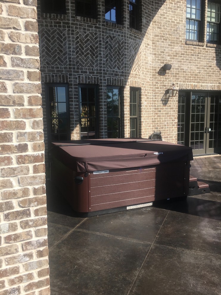 Example of a mid-sized transitional backyard concrete and rectangular hot tub design