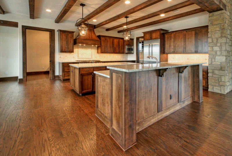 Inspiration for a rustic medium tone wood floor open concept kitchen remodel in Austin with medium tone wood cabinets, granite countertops, beige backsplash, stainless steel appliances and an island