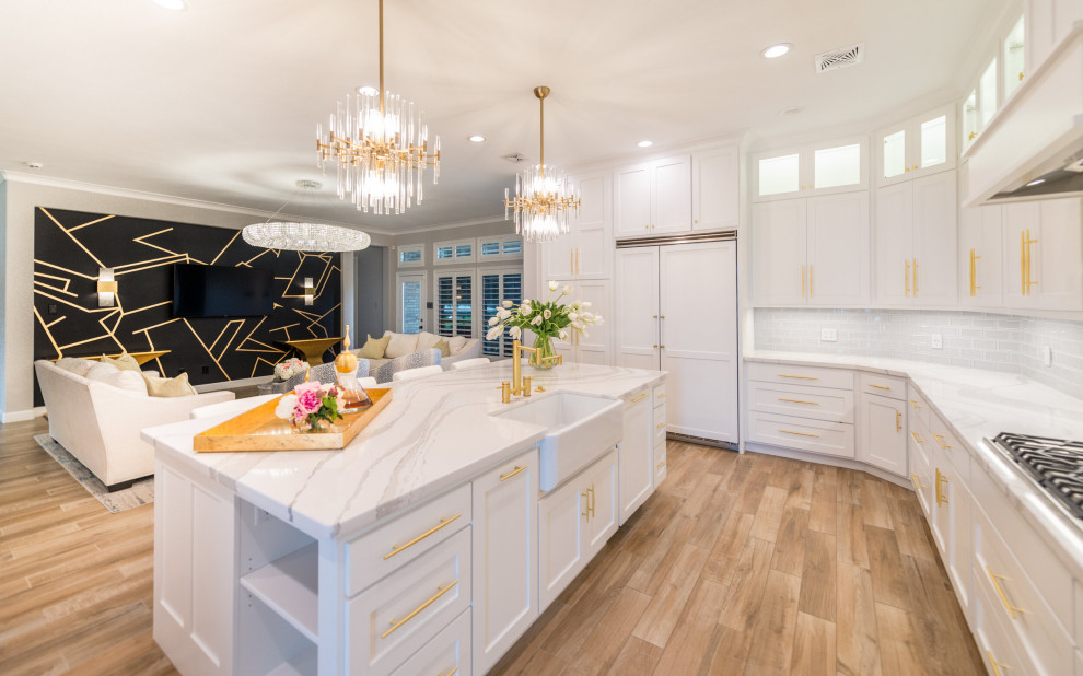 Design ideas for a large modern l-shaped kitchen/diner in Houston with a submerged sink, shaker cabinets, white cabinets, white splashback, metro tiled splashback, integrated appliances, vinyl flooring, an island, brown floors and a vaulted ceiling.
