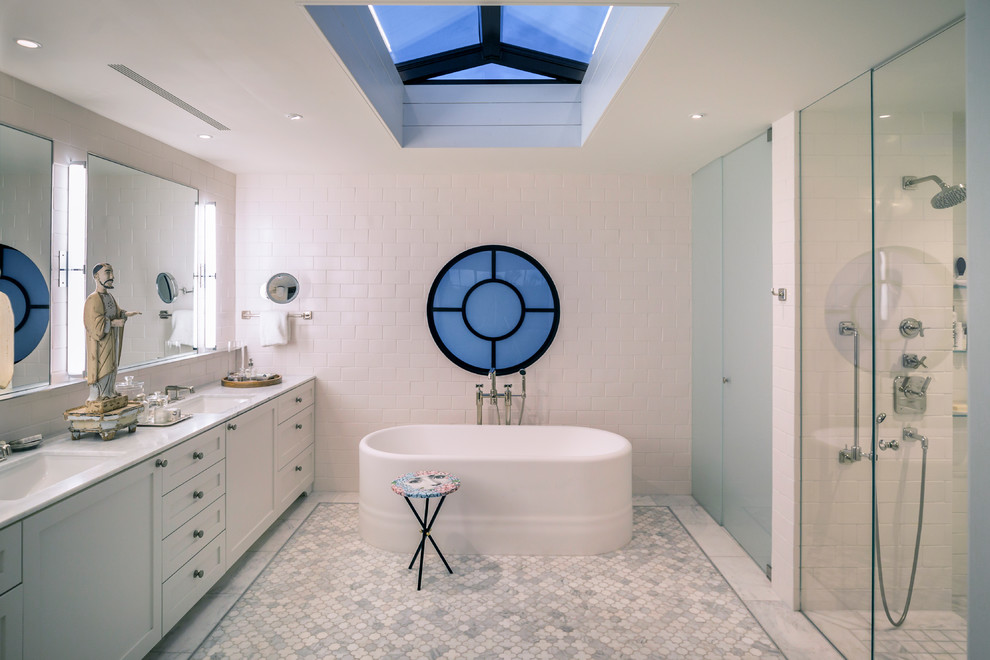 Inspiration for a transitional master bathroom in Orange County with shaker cabinets, white cabinets, a freestanding tub, a curbless shower, white tile, subway tile, marble floors, an undermount sink, white floor, a hinged shower door and white benchtops.