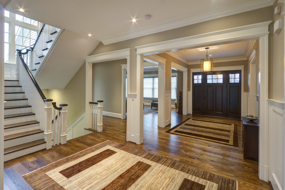 Inspiration for a transitional entry hall in DC Metro with grey walls, medium hardwood floors and a dark wood front door.