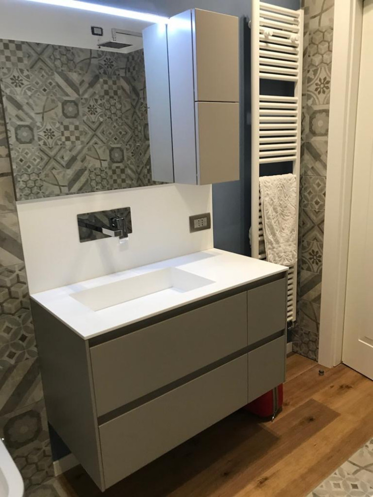 Small contemporary 3/4 bathroom in Milan with flat-panel cabinets, beige cabinets, a two-piece toilet, beige tile, porcelain tile, beige walls, medium hardwood floors, an integrated sink, a niche, a single vanity and a floating vanity.