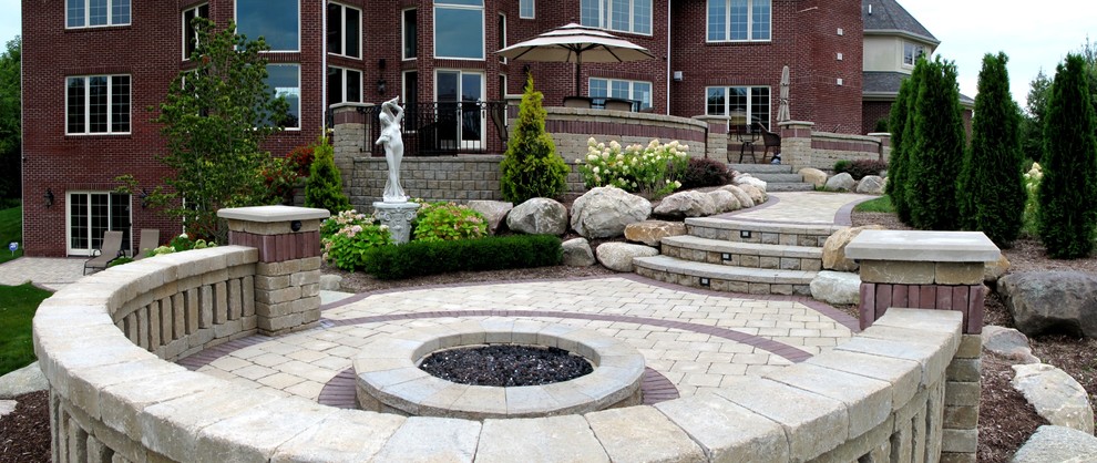 Photo of a transitional backyard brick landscaping in Detroit with a fire pit.