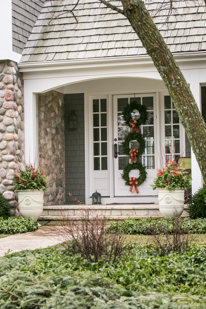 This is an example of a mid-sized transitional partial sun front yard stone landscaping in Chicago for winter.