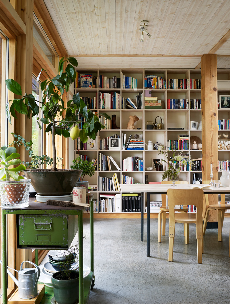 Design ideas for an asian family room in Stockholm with a library, beige walls, concrete floors and grey floor.